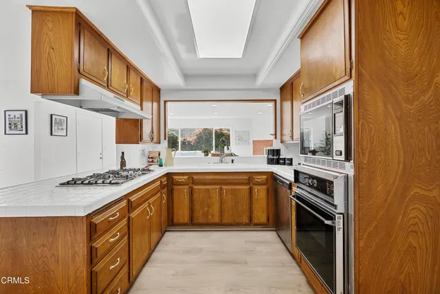 a kitchen with stainless steel appliances granite countertop a stove a sink and a refrigerator