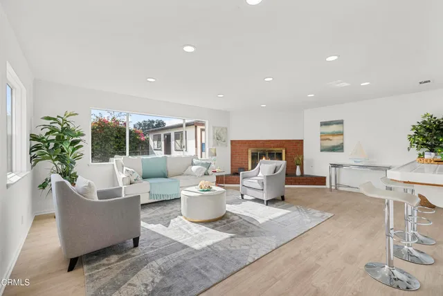 a living room with fireplace furniture and a potted plant