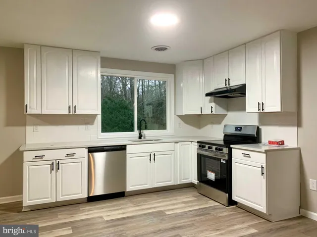 a kitchen with a sink stove and cabinets