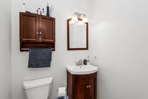 a bathroom with a sink a toilet and mirror