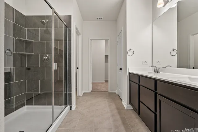 a bathroom with a shower sink and mirror