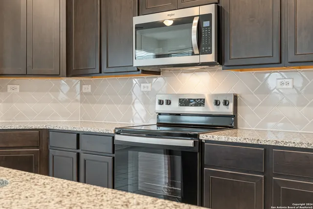 a kitchen with stainless steel appliances granite countertop a stove microwave and cabinets