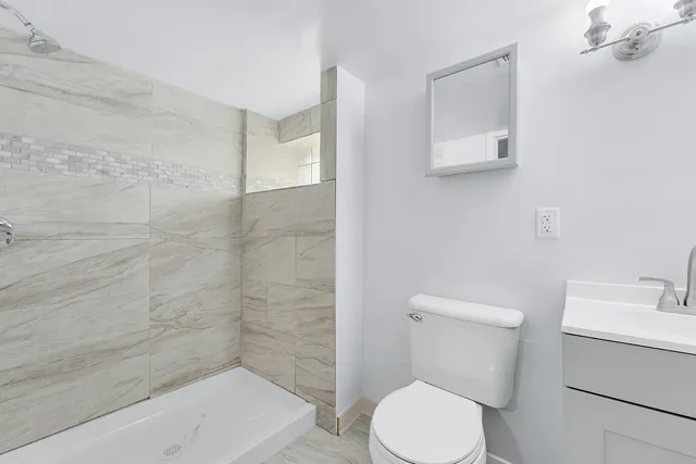 a white toilet sitting next to a bath tub