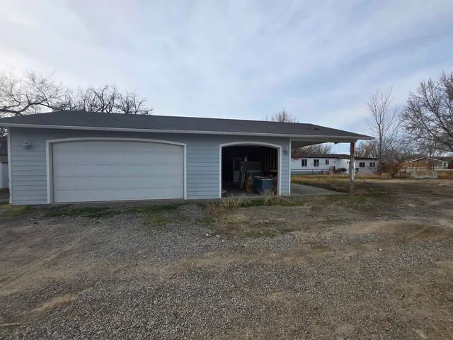 a view of dirt yard with large trees