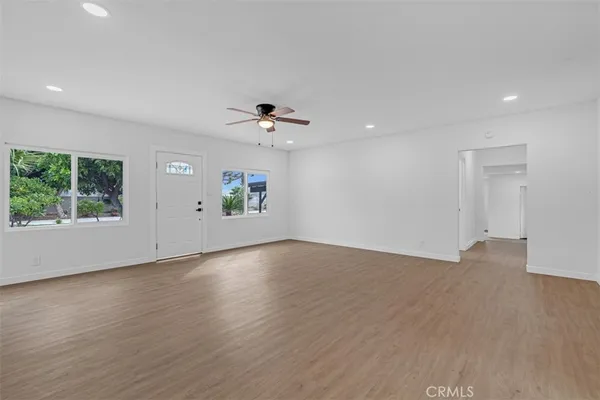 a view of a room with wooden floor and a ceiling fan