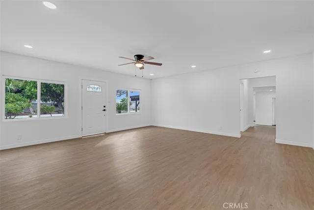 a view of a room with wooden floor and a ceiling fan