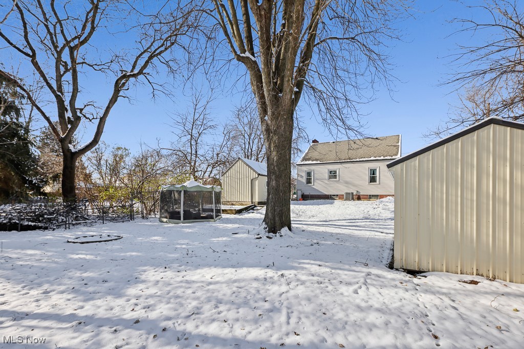 4722 Navarre Road Southwest Canton, OH 44706 - Photo 37 of 38 Yard layered in snow with a trampoline and an outdoor structure