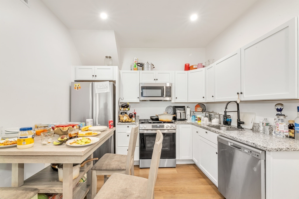 36 Brookledge Street Boston, MA 02121 - Photo 13 of 31 a kitchen that has a lot of white cabinets and wooden floor