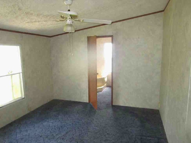 Blue carpeted flooring and textured walls define this private bedroom space with an attached bath.