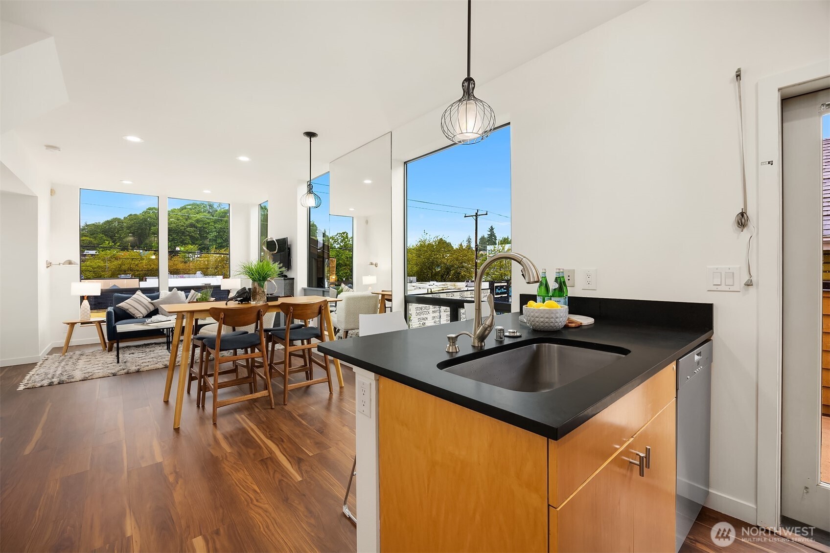 3818 South Hudson Street, Unit A Seattle, WA 98118 - Photo 11 of 31 a kitchen with kitchen island granite countertop a sink a counter top space and living room view