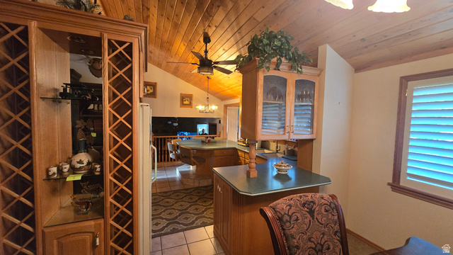 11077 Susan Drive Sandy, UT 84092 - Photo 12 of 20 Kitchen featuring a chandelier, glass insert cabinets, wooden ceiling, pendant lighting, and light tile patterned floors