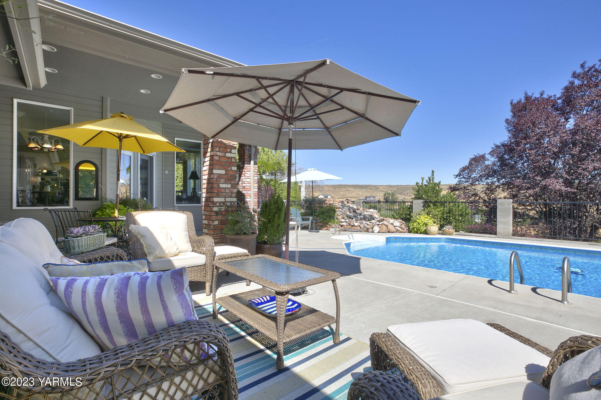 11521 Marble Extension Yakima, WA 98908 - Photo 28 of 40 a view of a patio with couches table and chairs under an umbrella