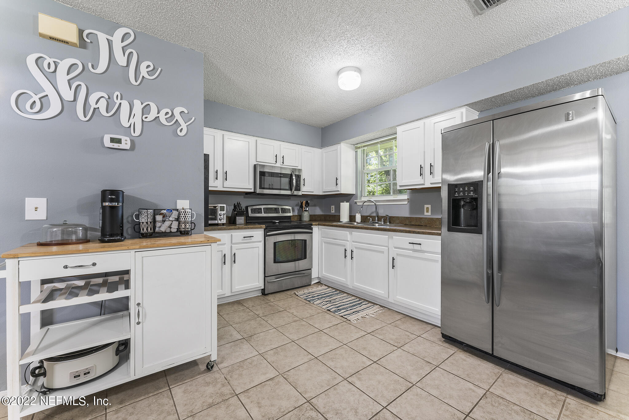 648 West Oliver Street Baldwin, FL 32234 - Photo 11 of 30 a kitchen with stainless steel appliances cabinets a microwave and a window
