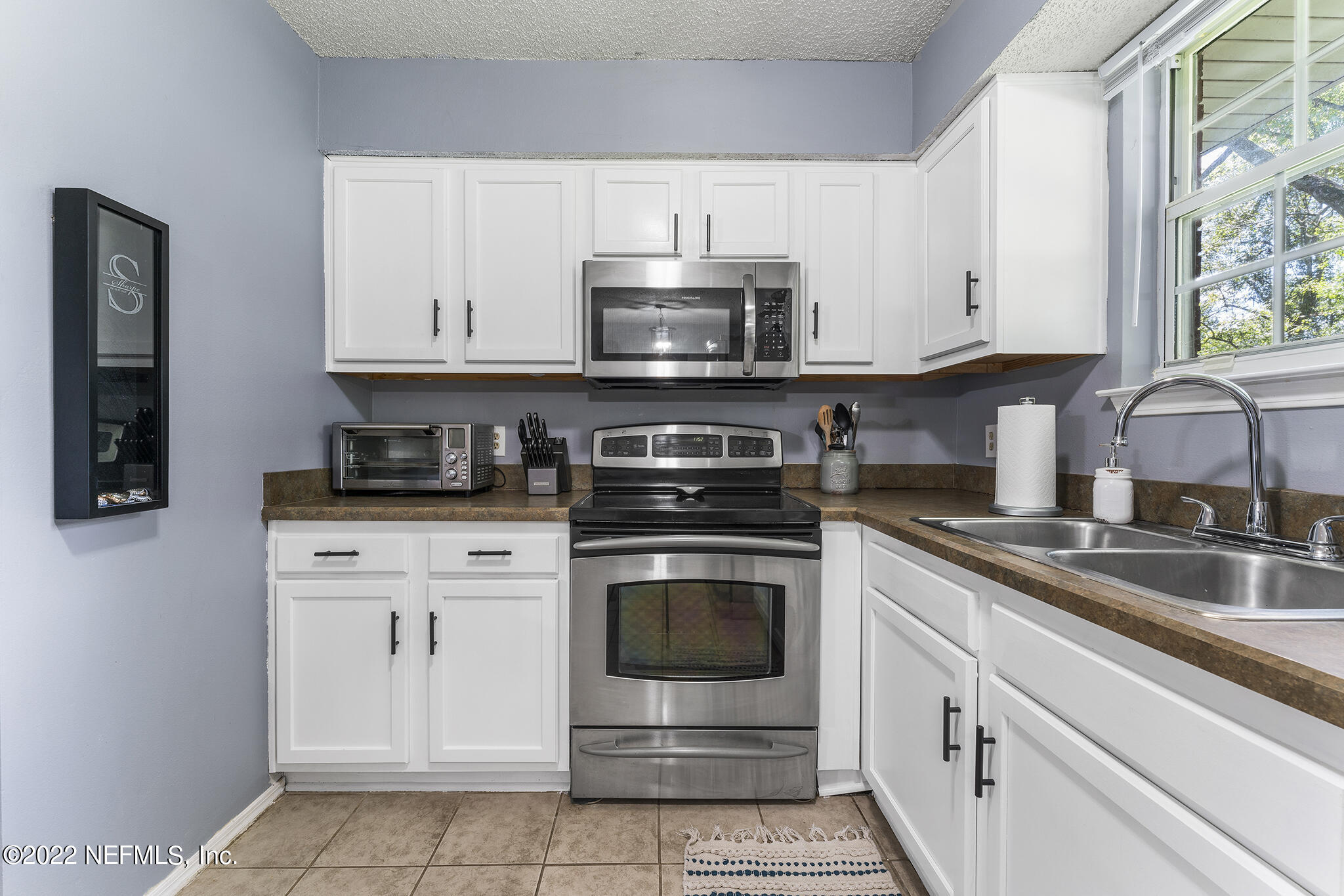 648 West Oliver Street Baldwin, FL 32234 - Photo 12 of 30 a kitchen with stainless steel appliances granite countertop a stove sink and cabinets