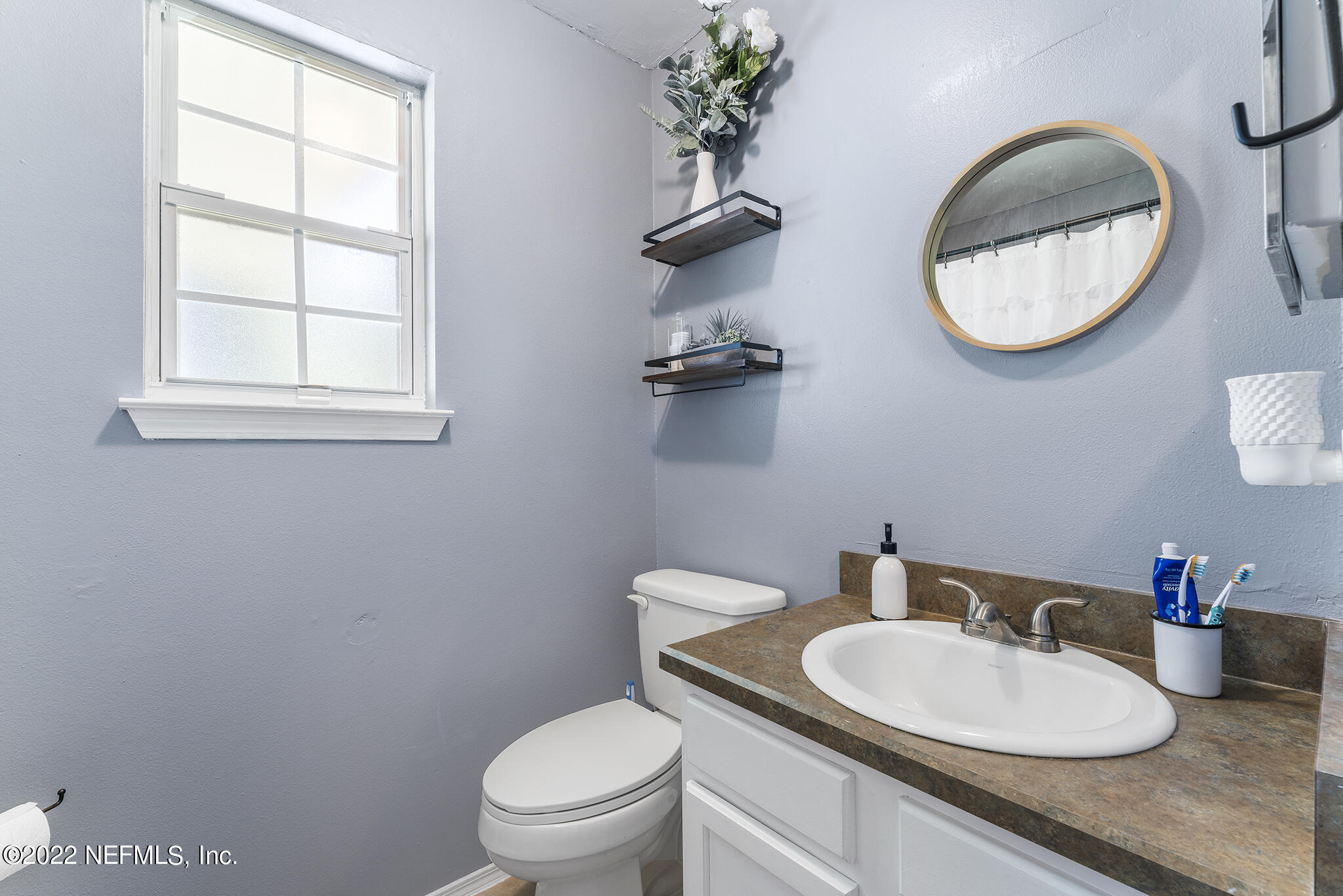 648 West Oliver Street Baldwin, FL 32234 - Photo 15 of 30 a bathroom with a toilet a sink and mirror