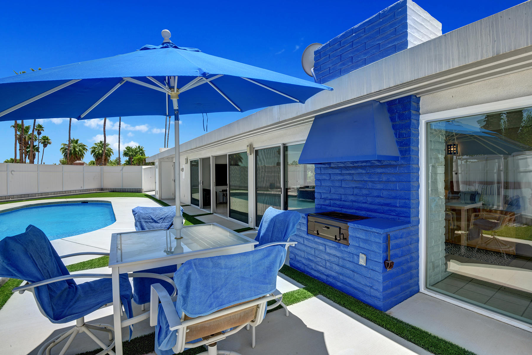 71704 Tunis Road Rancho Mirage, CA 92270 - Photo 9 of 47 a view of a patio with a dining table and chairs under an umbrella