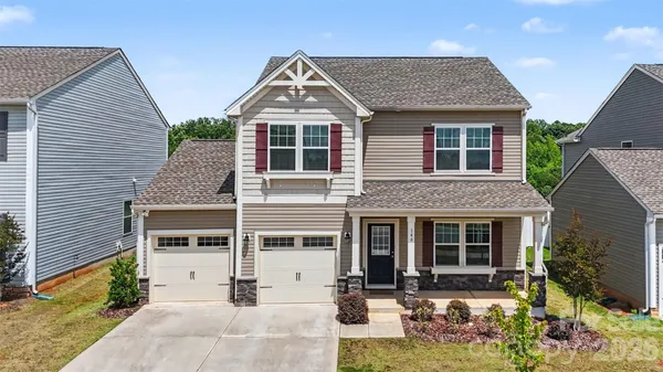 a front view of a house with yard and parking