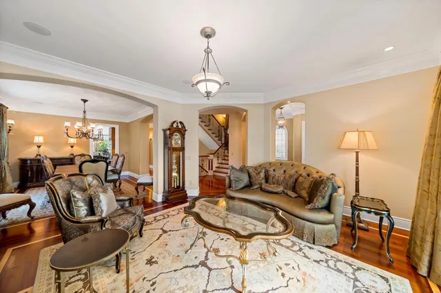 a living room with furniture a dining table and a chandelier