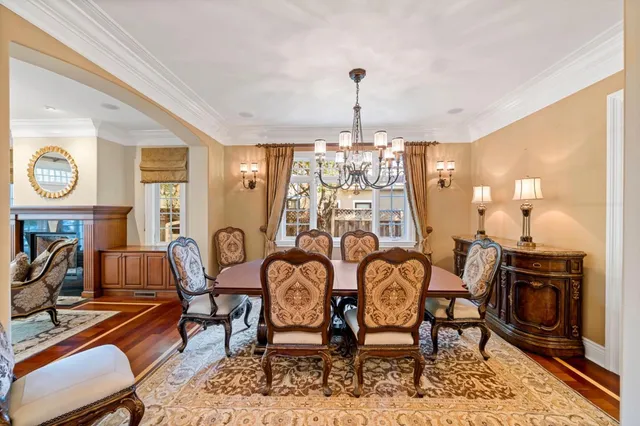 a view of a dining room with furniture a chandelier and wooden floor