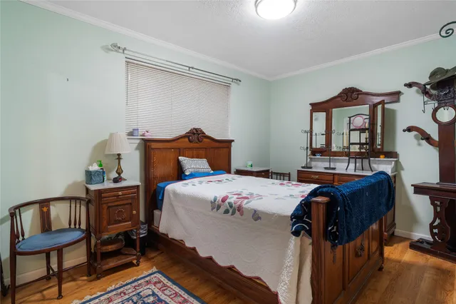 a bedroom with a bed a dresser and chair