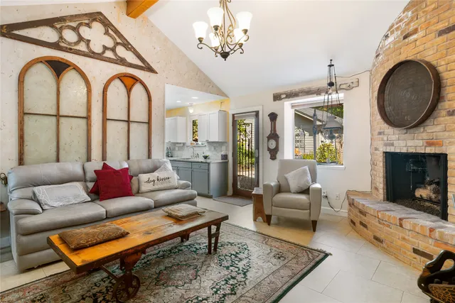 a living room with furniture a fireplace and a chandelier