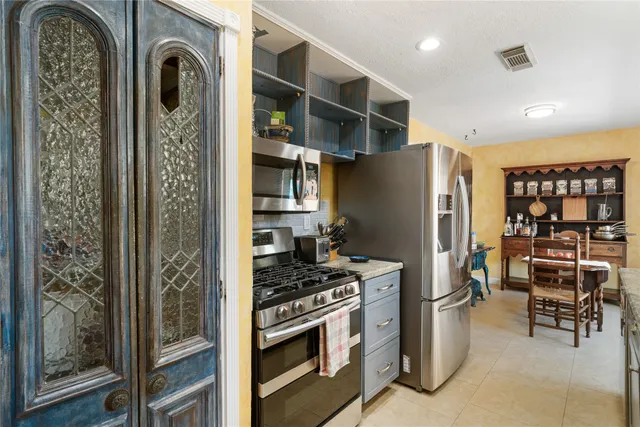 a kitchen with stainless steel appliances granite countertop a refrigerator and a stove top oven
