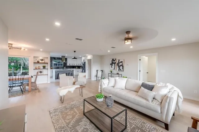a living room with furniture and a view of kitchen