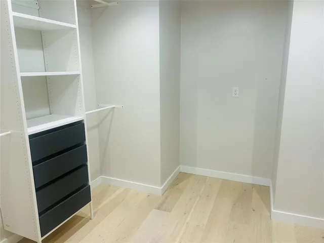 a view of walk in closet with empty racks