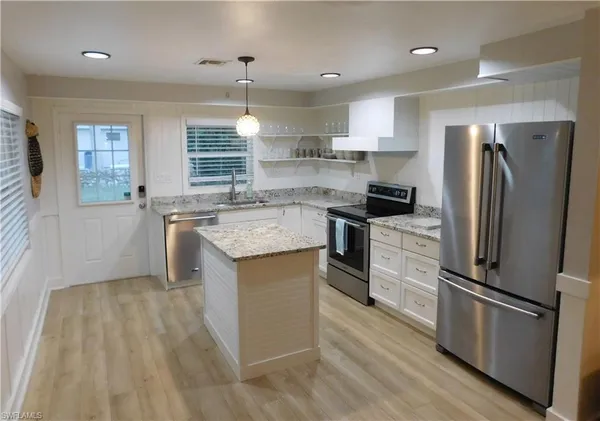 a kitchen with stainless steel appliances granite countertop a sink stove and refrigerator