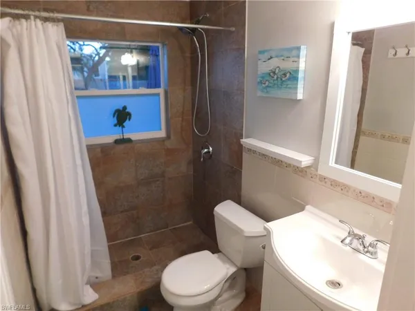 a white toilet sitting next to a bathroom sink and tub