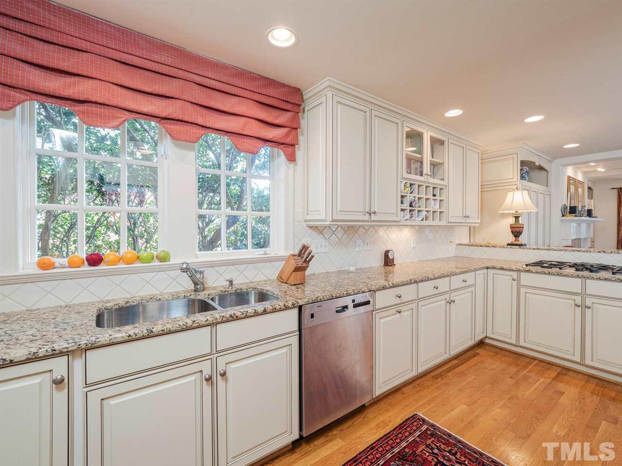 1811 Craig Street Raleigh, NC 27608 - Photo 6 of 28 a kitchen with granite countertop a sink and white cabinets