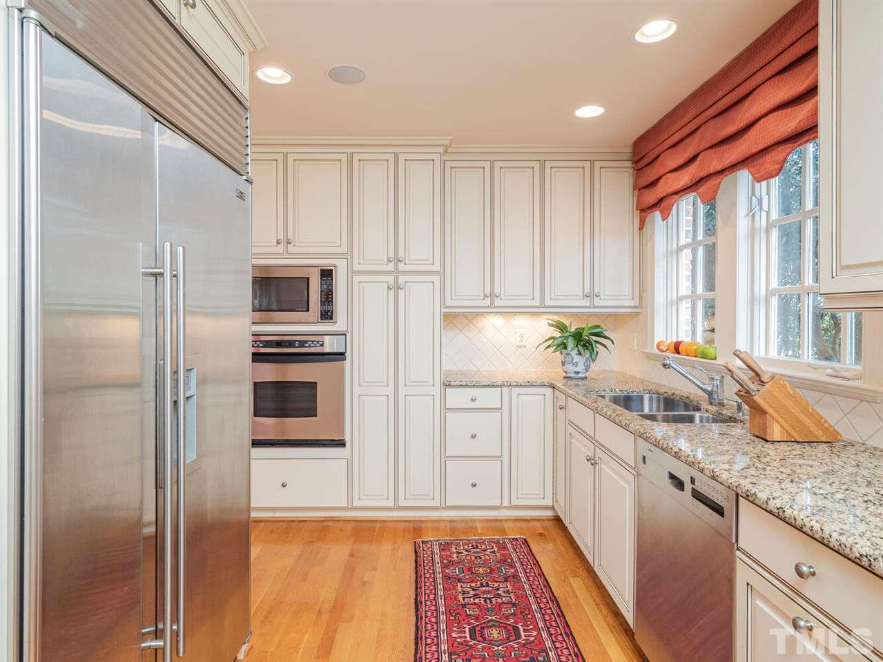 1811 Craig Street Raleigh, NC 27608 - Photo 8 of 28 a kitchen with granite countertop stainless steel appliances a refrigerator sink and microwave