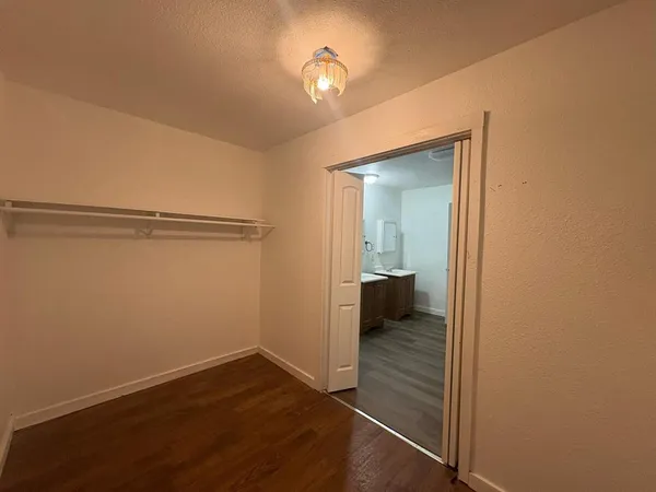 a view of a room with wooden floor cabinet and a bathroom