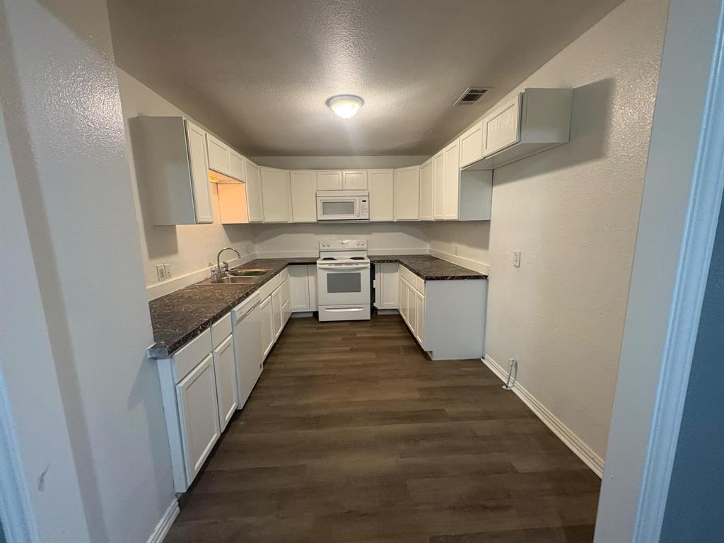 2998 County Road 658 Farmersville, TX 75442 - Photo 18 of 26 a kitchen with cabinets and wooden floor