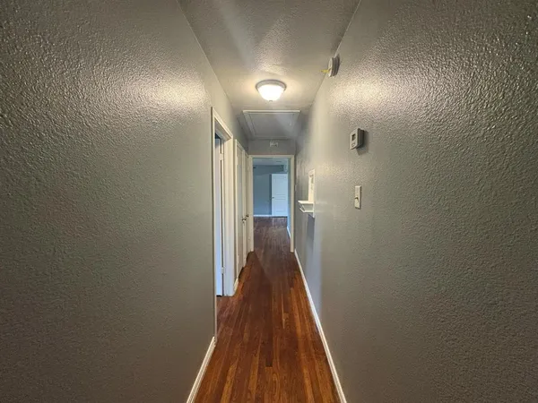 a view of a hallway with wooden floor