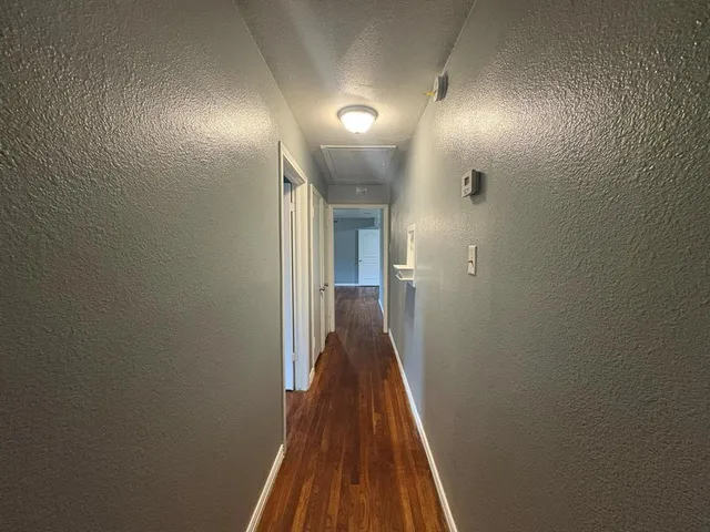 a view of a hallway with wooden floor