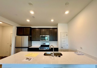 2136 Bodega Road, Unit 2136 Oswego, IL 60543 - Photo 9 of 19 a kitchen with stainless steel appliances a refrigerator sink and microwave