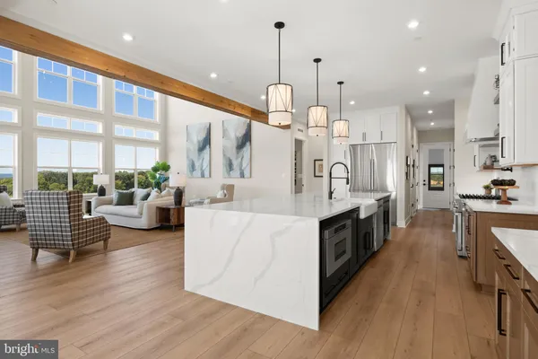 a large kitchen with stainless steel appliances lots of counter space and a chandelier