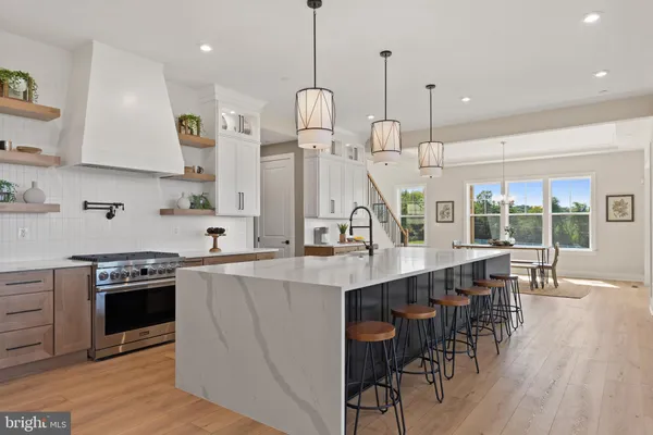 a living room with furniture a flat screen tv and kitchen view