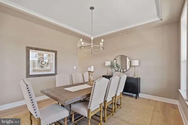 a view of a dining room with furniture a chandelier and wooden floor