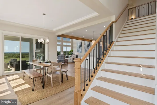 a dining room with furniture a chandelier and wooden floor