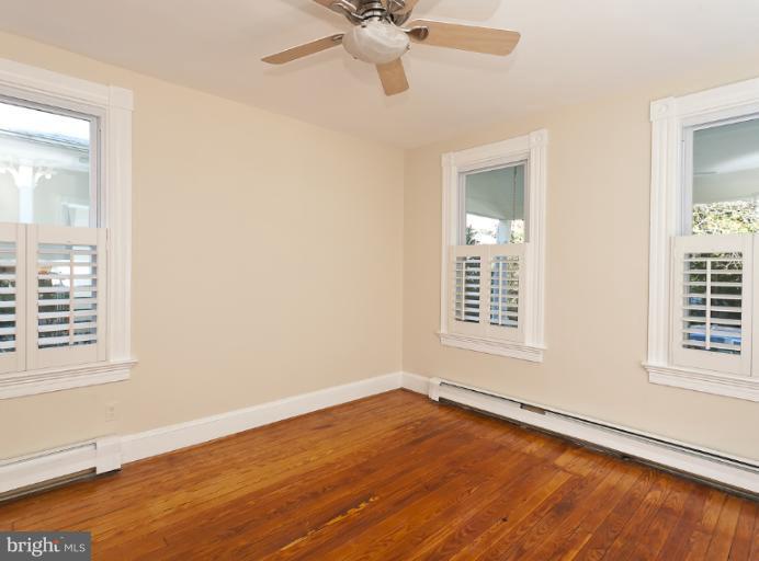 4612 Schenley Road Baltimore, MD 21210 - Photo 1 of 23 an empty room with wooden floor fan and windows