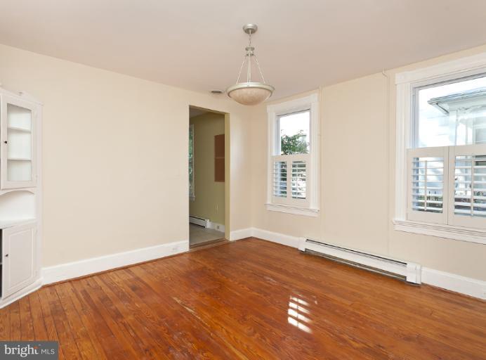 4612 Schenley Road Baltimore, MD 21210 - Photo 2 of 23 an empty room with wooden floor and windows