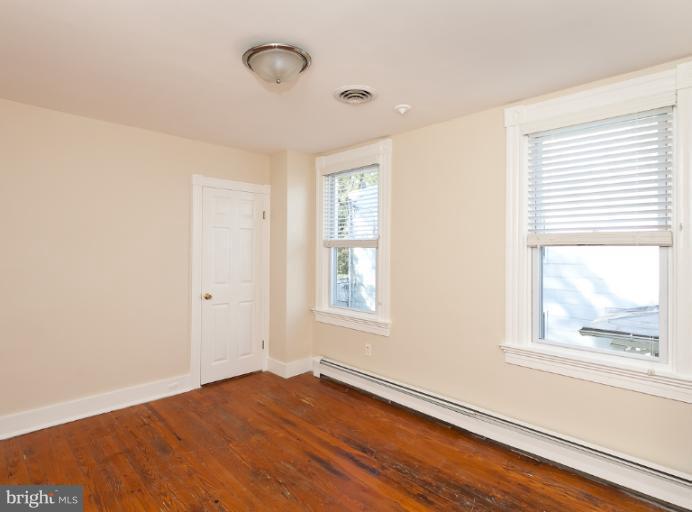 4612 Schenley Road Baltimore, MD 21210 - Photo 11 of 23 a view of an empty room with wooden floor and a window