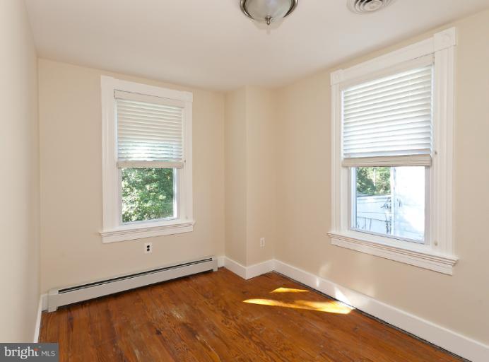4612 Schenley Road Baltimore, MD 21210 - Photo 4 of 23 a view of an empty room with wooden floor and a window