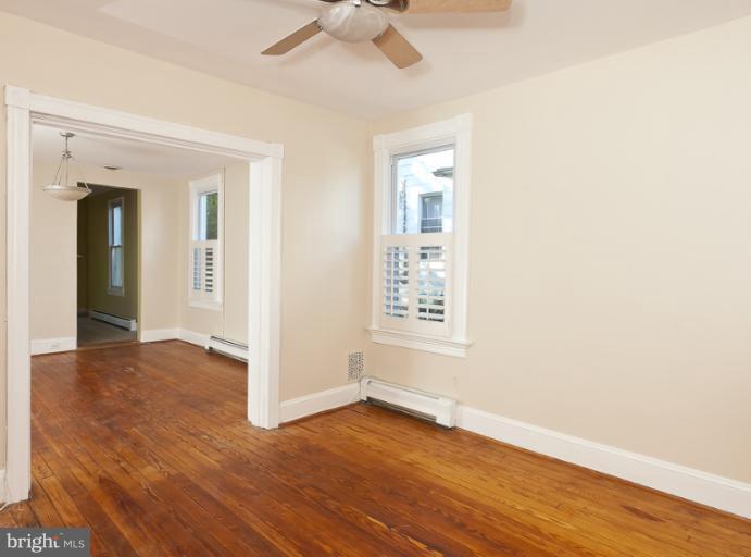 4612 Schenley Road Baltimore, MD 21210 - Photo 7 of 23 an empty room with wooden floor chandelier fan and windows