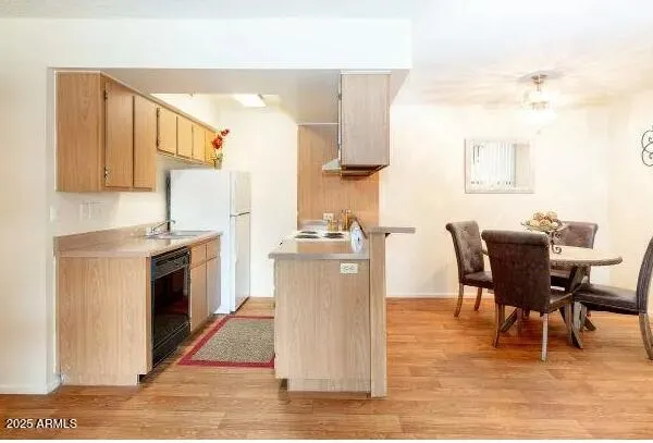 a dining room with kitchen island stainless steel appliances wooden floor dining table and chair
