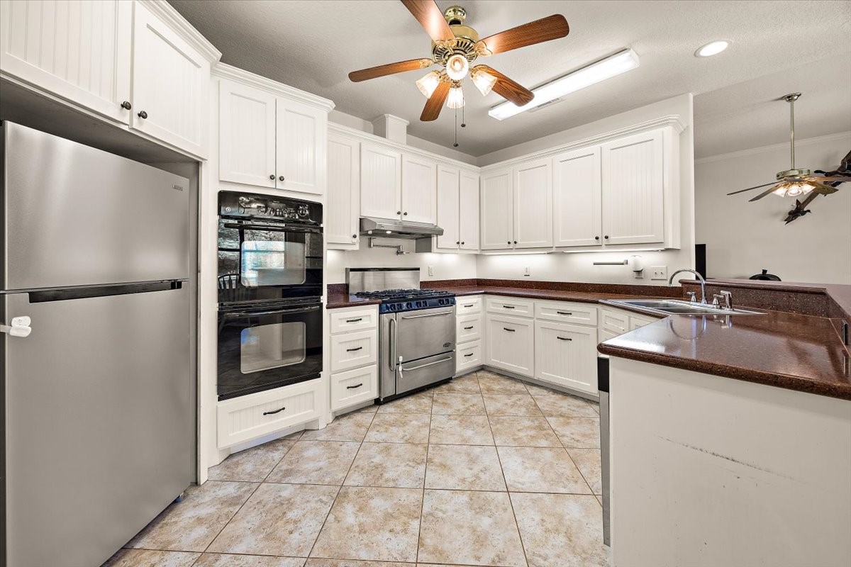 394 Farm To Market 230 Trinity, TX 75862 - Photo 17 of 50 a kitchen with a sink a refrigerator and cabinets