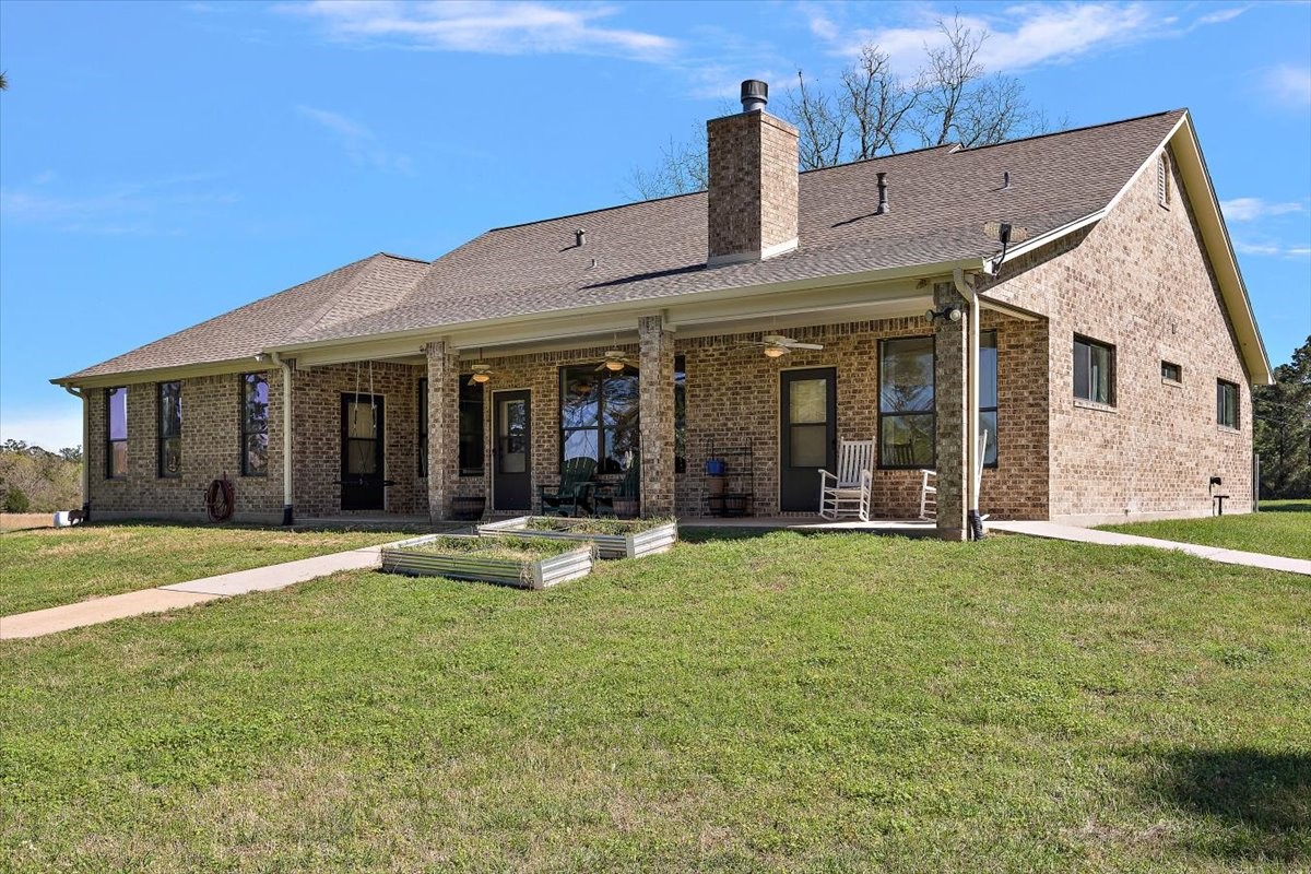 394 Farm To Market 230 Trinity, TX 75862 - Photo 9 of 50 a front view of a house with a garden and yard