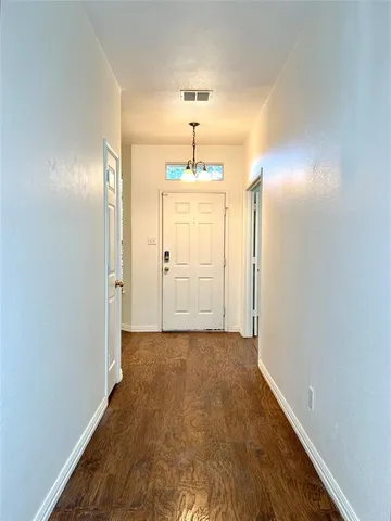a view of a bedroom with wooden floor closet and windows